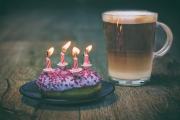 Donut zum Geburtstag mit Kerzen und Kaffee