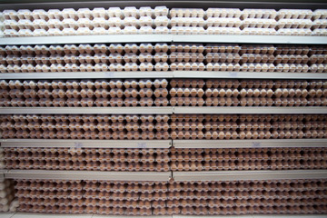 Beautiful big eggs standing on the stall at the marketplace,buyer taking with hands several eggs from package,holding hands,closeup,agriculture products, sell,poultry.
