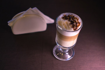 Coffee in a glass cup in a cafe with a blurred background.