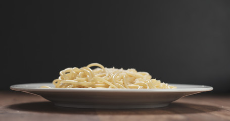 grated aged parmesan cheese on spaghetti