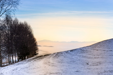 snowy rolling hills with mountain view