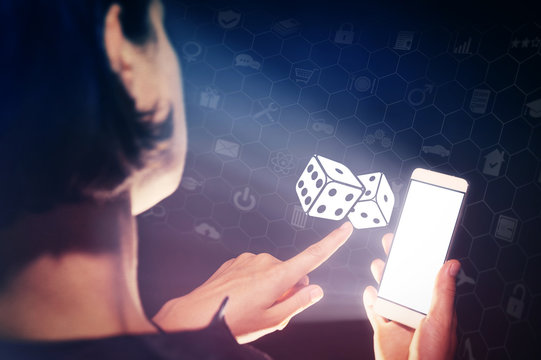 Image of a girl with a smartphone in hands. She presses on the dice icon. Concept of entertainment, gambling, fortune.