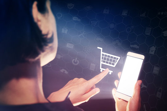 Image of a woman with a smartphone in her  hand. She makes purchases with her gadget. Concept of online shopping.