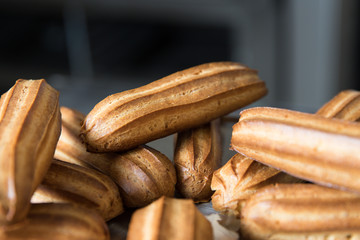 Fresh eclairs lying on a metal tray