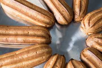 Fresh eclairs lying on a metal tray