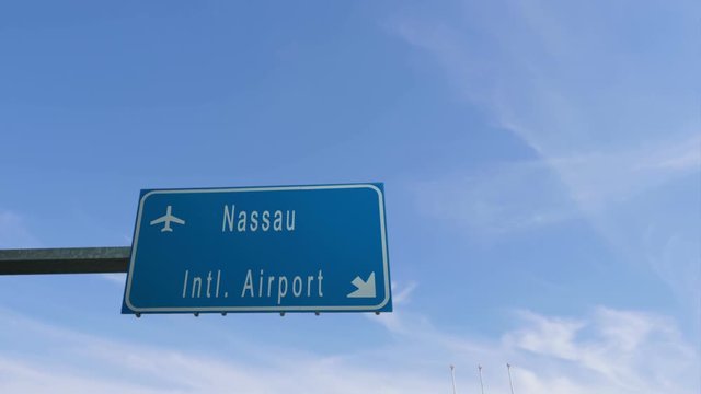 nassau airport sign airplane passing overhead