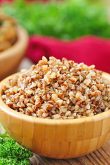 Buckwheat in a wooden bowl and fresh vegetables