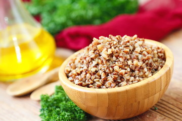 Buckwheat in a wooden bowl and fresh vegetables