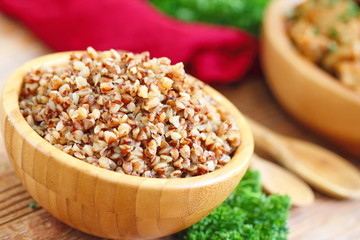 Buckwheat in a wooden bowl and fresh vegetables