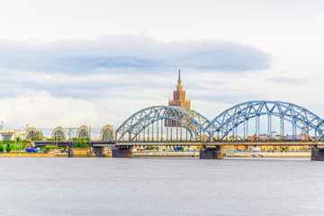view of the zeppelin hangars and the academy of sciences building next to a steel railway bridge in the Latvian capital Riga. © dudlajzov