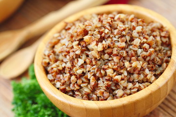 Buckwheat in a wooden bowl and fresh vegetables
