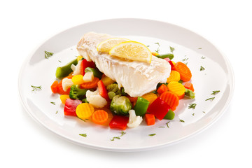 Fish dish - fried fish fillet and vegetables on white background