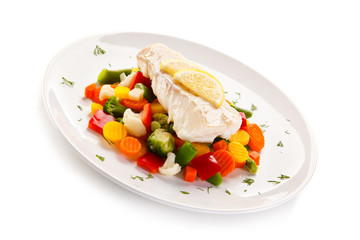 Fish dish - fried fish fillet and vegetables on white background