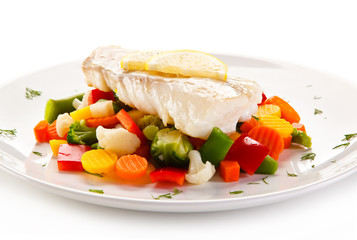 Fish dish - fried fish fillet and vegetables on white background