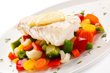 Fish dish - fried fish fillet and vegetables on white background