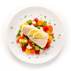 Fish dish - fried fish fillet and vegetables on white background