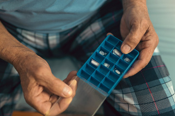 Senior Man Sitting On Bed At Home Taking Medication, close up