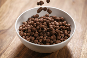 chocolate cereal balls fall in white bowl for breakfast