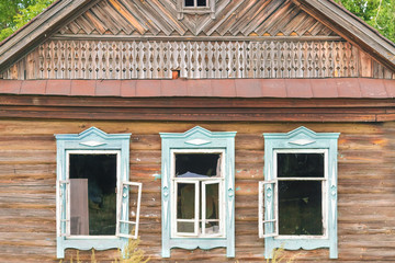 Old rustic wooden house with blue window frames