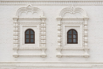 Fototapeta na wymiar Arched window with wooden frame in a white brick wall