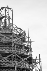Fototapeta na wymiar Stone tower with a dome and with wooden construction beams. Grayscale