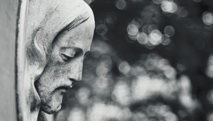 An ancient statue of the crucifixion of Jesus Christ in profile (religion, faith, death, suffering,...