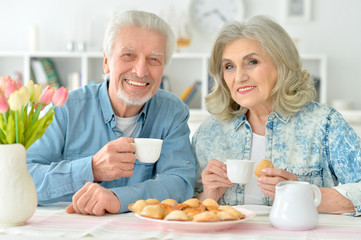 Obraz na płótnie Canvas senior couple drinking tea with cookies