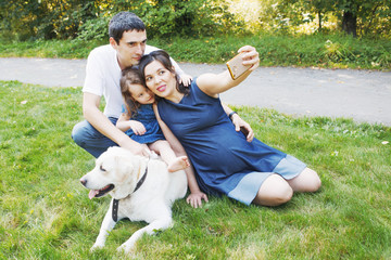 happy family with pet dog at picnic in a Sunny summer day. pregn