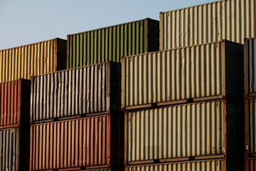 Stack of containers with different colors at the sea port waiting for shipping