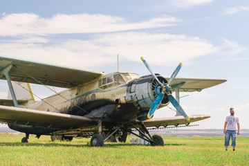 Fototapeta na wymiar Bearded man near an old plane in field
