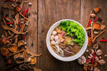 beef noodle on dark background with herb and nature ingredient. Asian food. Noodles, chicken and soy sauce. Top view.