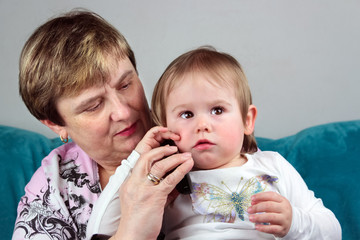 Frau Oma mit Baby Enkelkind am Telefon