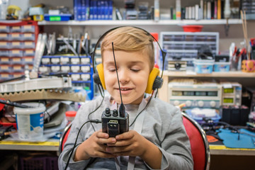 Happy boy with headphones using walkie talkie.