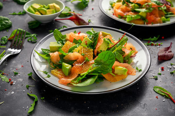 Fresh salmon salad with avocado, orange and green vegetables.