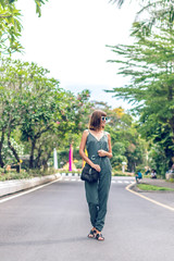 Fototapeta na wymiar Closeup attractive beautiful woman with snakeskin python handbag posing outdoors. Bali island.