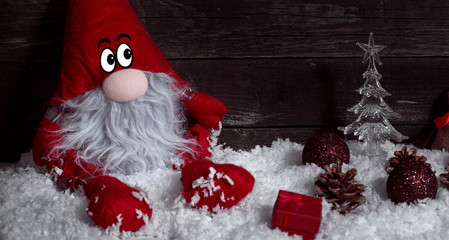 Funny Christmas dwarf on snow with Christmas decorative.