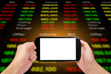 hand holdihg and touch screen smart phone,tablet,cellphone on stock chart market background.