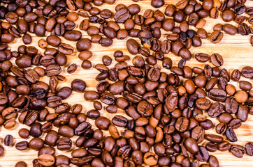 Pile of the roasted coffee beans on wooden table. Top view
