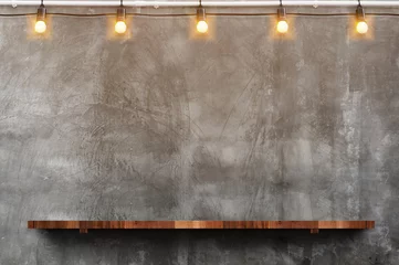 Foto auf Acrylglas Mauer Leeres braunes Holzbrettregal an der Grunge-Betonwand mit Glühbirnen-String-Party-Hintergrund, Mock-up für die Anzeige oder Montage von Produkt oder Design