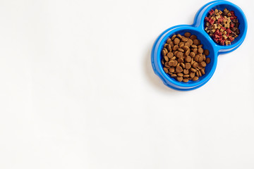 Dry pet food in bowl on white background top view