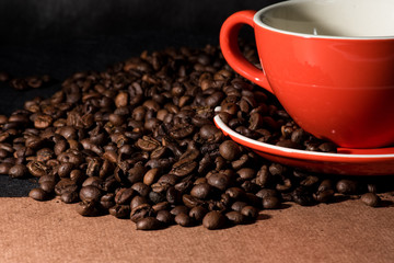 coffee in red cup and coffee beans are the background.