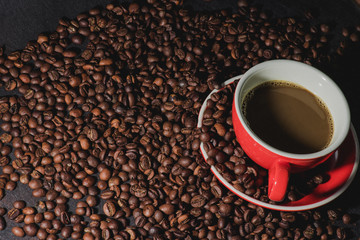 coffee in red cup and coffee beans are the background.