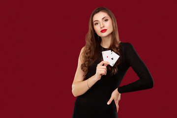 Beautiful caucasian woman in black dress with poker cards gambling in casino