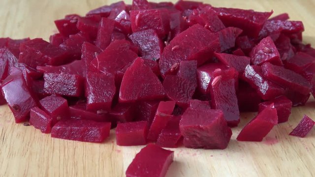 Canned beet slices on a wooden background. Sour small vegetable - beetroot (canned, soft)