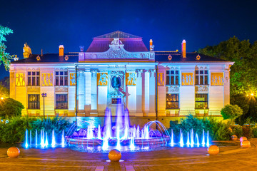 Night view of the Szczepanski Square with fountain and Palace of the Arts, opened in 1901 in Krakow, Poland.