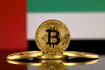 Physical version of Bitcoin (new virtual money) and United Arab Emirates Flag. Conceptual image for investors in cryptocurrency and Blockchain Technology in United Arab Emirates.