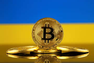 Physical version of Bitcoin (new virtual money) and Ukraine Flag. Conceptual image for investors in cryptocurrency and Blockchain Technology in Ukraine.