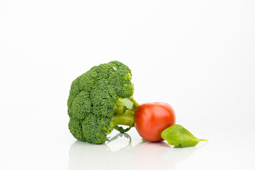Broccoli And Tomato On White Background With Reflection