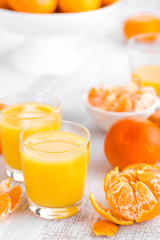 Tangerines, peeled tangerines and tangerine juice in glass. Mandarine juice.