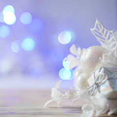 A gentle pastel Christmas and New Year background with a Christmas tree-tree toy in the foreground.  Multicolored glare from a garland in the back of a blurry background and free space for text.